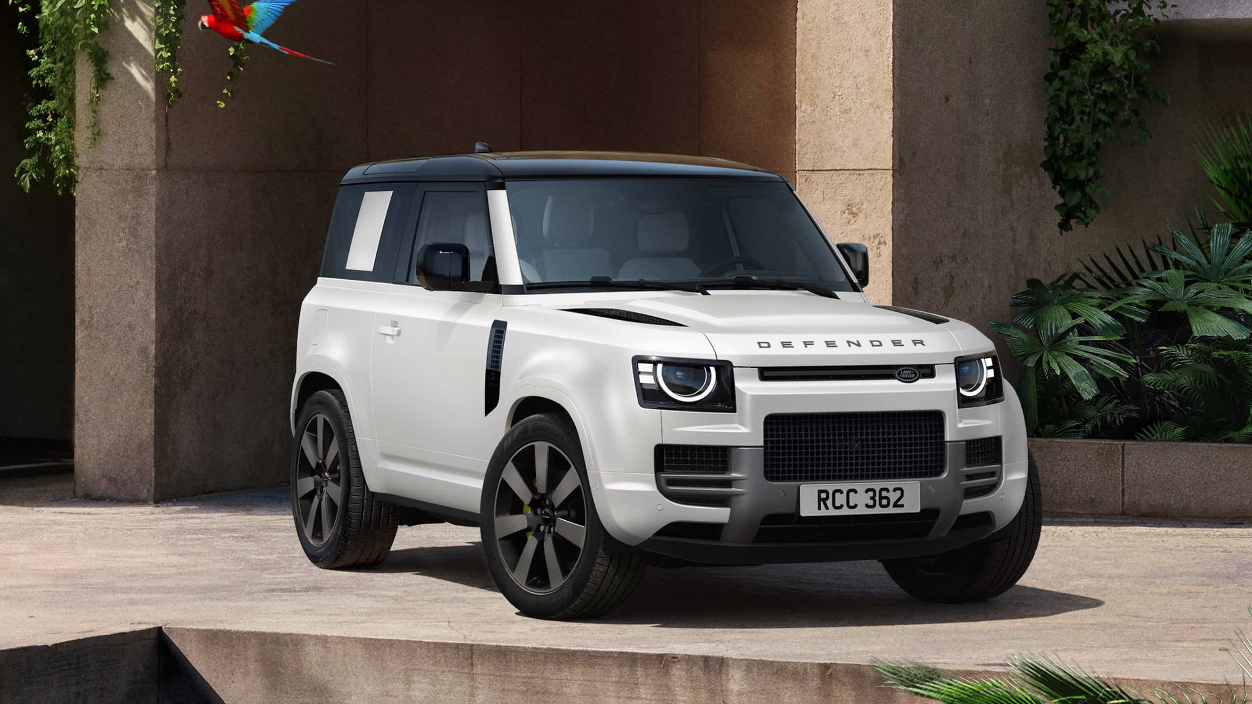 Defender parked in lush greenery and a shaded recessed space